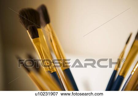 Stock Photo - Blue and Gold Paintbrushes in a Jar. Fotosearch