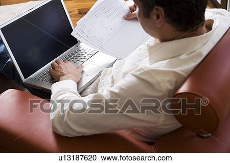 Man Working on laptop in modern living room View Large Photo Image Stock Image - Man Working on laptop in modern living room. Fotosearch