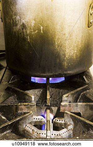 Stock Photo - Pot Boiling on Dirty Gas Burner. Fotosearch