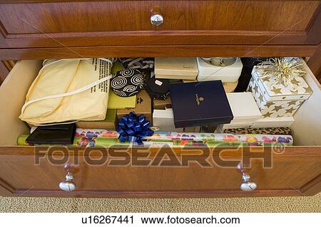Stock Image - Detail of open drawer with gift wrapping supplies.. Fotosearch