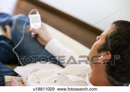 Stock Photo - Man Listening to MP3 Player. Fotosearch