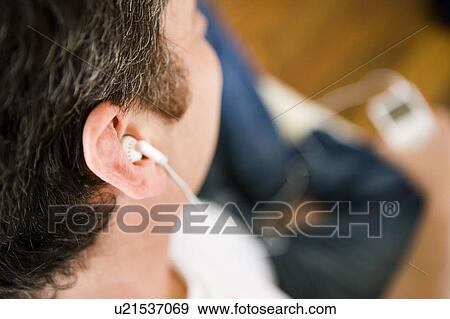 Stock Photo - Man listening to MP3 player. Fotosearch