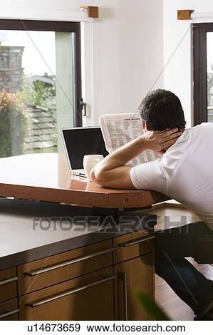 Man Reading Newspaper with Laptop and Coffee View Large Photo Image Stock Photo - Man Reading Newspaper with Laptop and Coffee. Fotosearch
