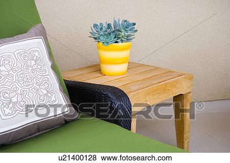 Detail of plant on table next to green chair. View Large Photo Image Stock Photo - Detail of plant on table next to green chair.. Fotosearch
