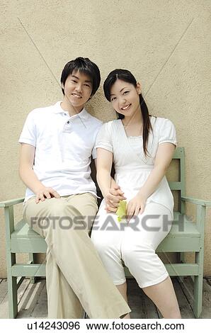 Stock Photograph - Couple sitting a bench. Fotosearch
