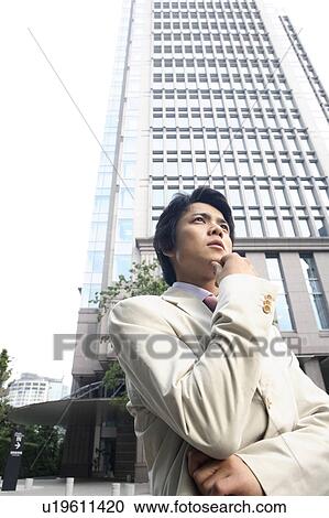 Stock Image - Businessman and a high-rise building. Fotosearch