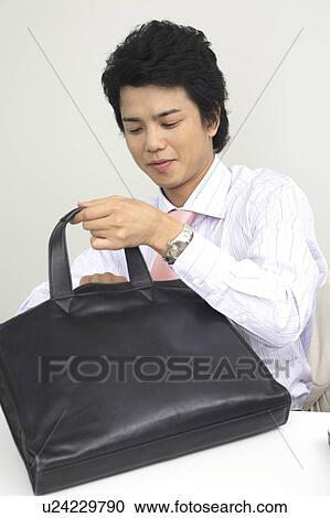Businessman arranging a bag View Large Photo Image Stock Image - Businessman arranging a bag. Fotosearch