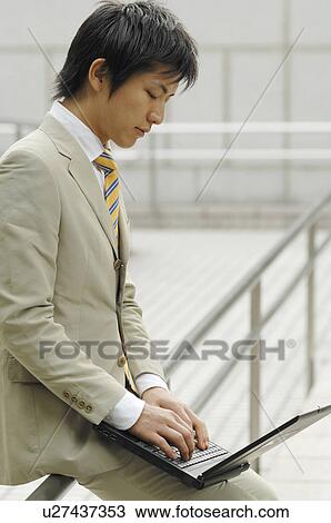 Stock Image - Businessman hitting the keyboard of the laptop PC. Fotosearch
