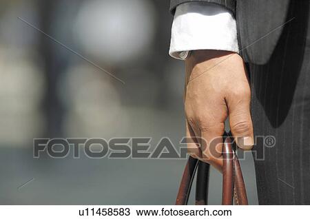 Stock Image - Hand of the businessman with the bag. Fotosearch