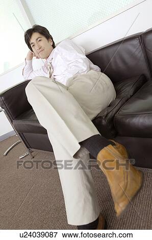 Stock Photo - Office worker who relaxes with the sofa. Fotosearch