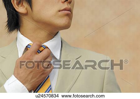 businessman putting on a necktie View Large Photo Image Picture - businessman putting on a necktie. Fotosearch