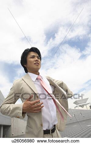 Businessman putting on a suit View Large Photo Image Stock Image - Businessman putting on a suit. Fotosearch
