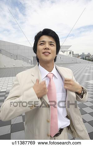 Businessman putting on a suit View Large Photo Image Stock Photo - Businessman putting on a suit. Fotosearch