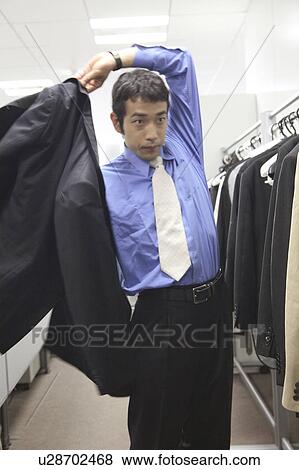 Businessman putting on a suit View Large Photo Image Stock Photo - Businessman putting on a suit. Fotosearch