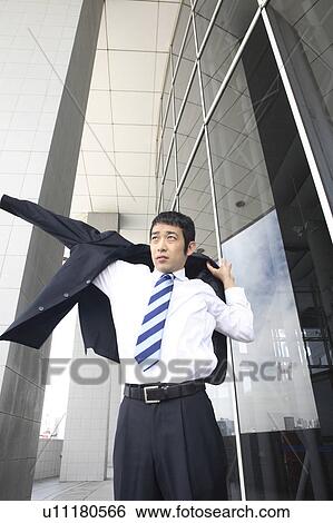 Businessman putting on a suit View Large Photo Image Stock Photograph - Businessman putting on a suit. Fotosearch