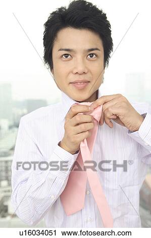 Businessman putting on a tie View Large Photo Image Stock Image - Businessman putting on a tie. Fotosearch