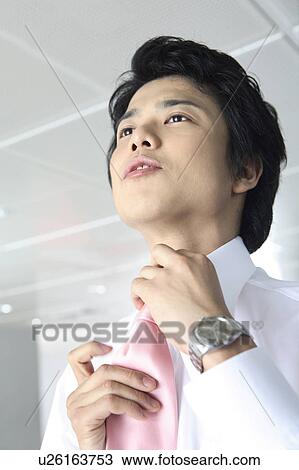 Businessman putting on a tie View Large Photo Image Stock Image - Businessman putting on a tie. Fotosearch