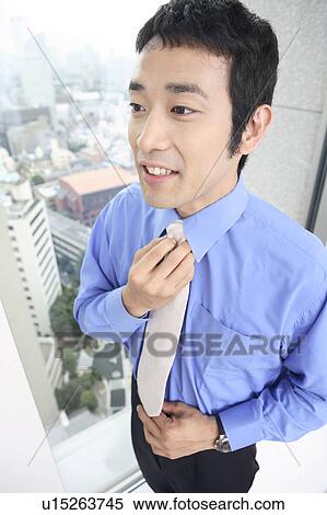 Businessman putting on a tie View Large Photo Image Stock Photography - Businessman putting on a tie. Fotosearch