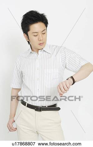 Stock Photo - Businessman to see a wristwatch. Fotosearch