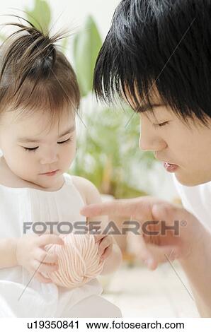 Stock Image - Father taking care of his baby. Fotosearch