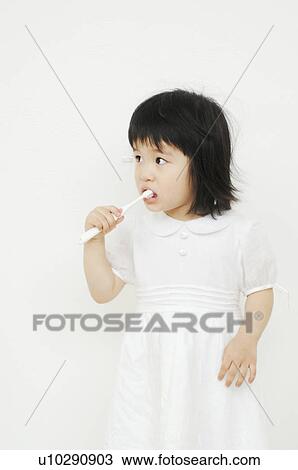 Stock Image - Girl brushing her teeth. Fotosearch