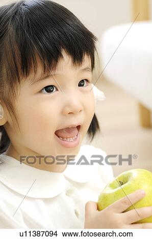 Girl having an apple View Large Photo Image Picture - Girl having an apple. Fotosearch