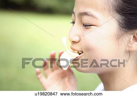 Girl who eats a crisp View Large Photo Image Stock Photo - Girl who eats a crisp. Fotosearch