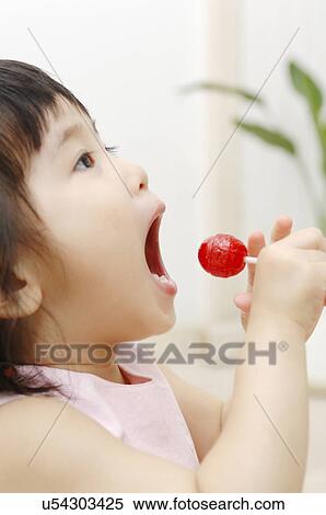 Infant who eats a candy View Large Photo Image Stock Photography - Infant who eats a candy. Fotosearch