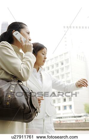 Stock Image - Business lady who speaks with the cell phone. Fotosearch