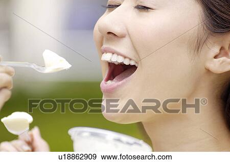 Stock Photo - Woman who eats ice. Fotosearch