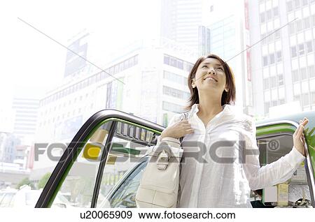 Woman who gets off the taxi View Large Photo Image Stock Photo - Woman who gets off the taxi. Fotosearch