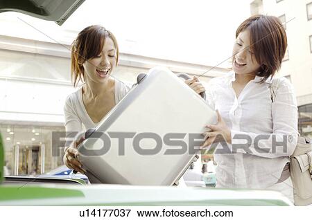 Stock Photo - Women who loads a taxi with the luggage. Fotosearch