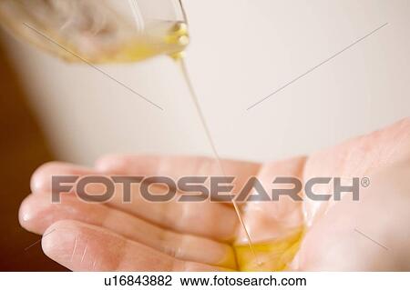 Stock Image - Palm of the hand receiving oil. Fotosearch