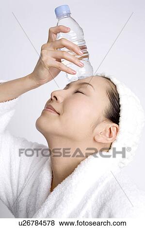 Stock Photo - Woman cooling head in PET bottle. Fotosearch