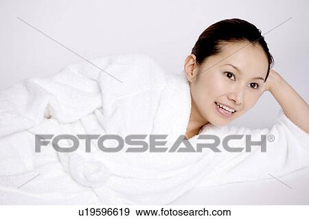 Stock Photo - Woman who lies in a bathrobe. Fotosearch