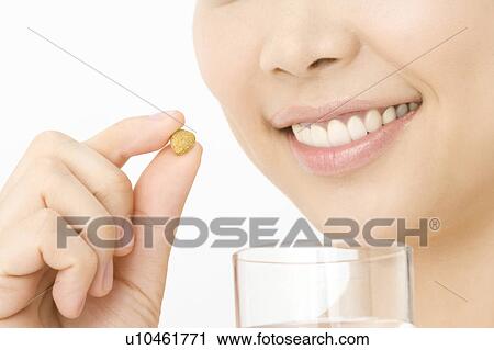 Woman who takes a supplement View Large Photo Image Stock Image - Woman who takes a supplement. Fotosearch