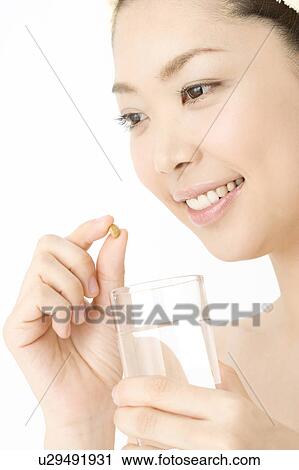 Woman who takes a supplement View Large Photo Image Stock Image - Woman who takes a supplement. Fotosearch