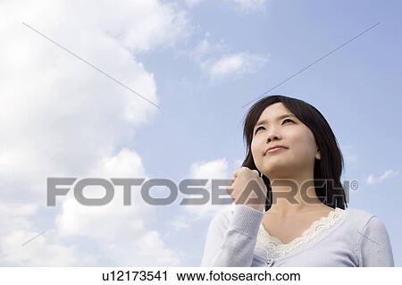Stock Image - Sky and woman. Fotosearch