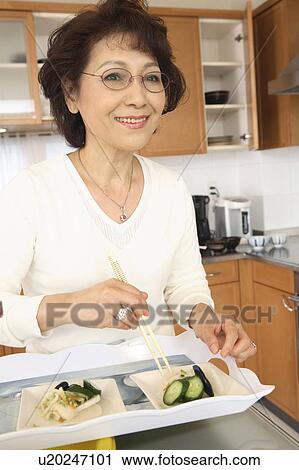 Stock Image - Woman eats a meal. Fotosearch