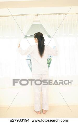 Woman opening a curtain View Large Photo Image Picture - Woman opening a curtain. Fotosearch