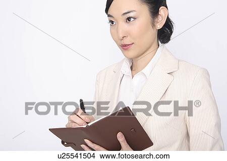 Business lady writing something in a notebook View Large Photo Image Picture - Business lady writing something in a notebook. Fotosearch