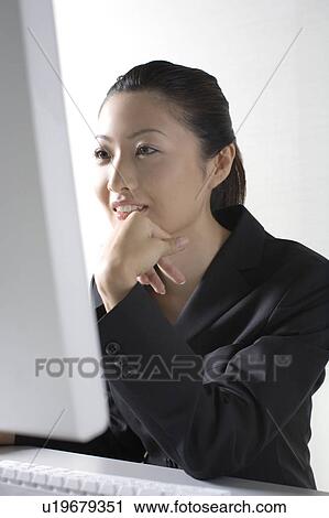 Stock Image - Woman operating a PC. Fotosearch