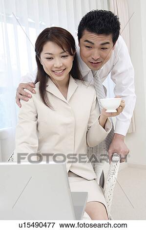 Couple looking at a PC View Large Photo Image Stock Photo - Couple looking at a PC. Fotosearch