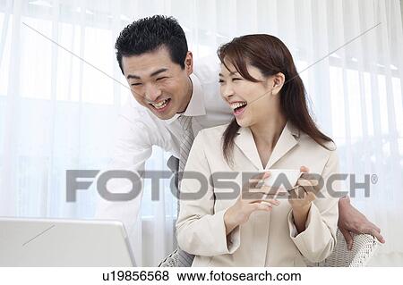 Couple looking at a PC View Large Photo Image Stock Photo - Couple looking at a PC. Fotosearch