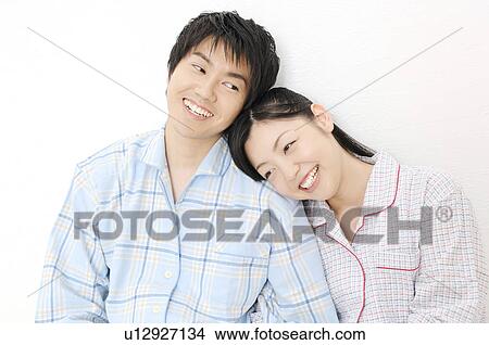 Picture - Couple putting on pjamas. Fotosearch