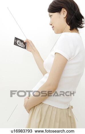 Pregnant woman watching a photograph View Large Photo Image Stock Image - Pregnant woman watching a photograph. Fotosearch