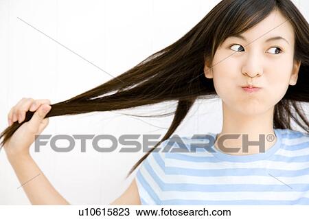 Stock Image - Woman drawing her own hair. Fotosearch