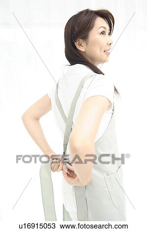 Woman putting on an apron View Large Photo Image Stock Image - Woman putting on an apron. Fotosearch