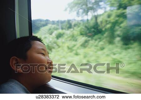 Boy on train looking out window View Large Photo Image Stock Image - Boy on train looking out window. Fotosearch
