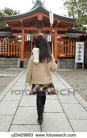 Stock Image - Girl walking at shrine. Fotosearch